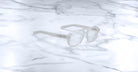 Jacques Marie Mage Evans: Oversized clear rectangular acetate eyeglasses by Jacques Marie Mage, handcrafted and displayed on a white marble surface.