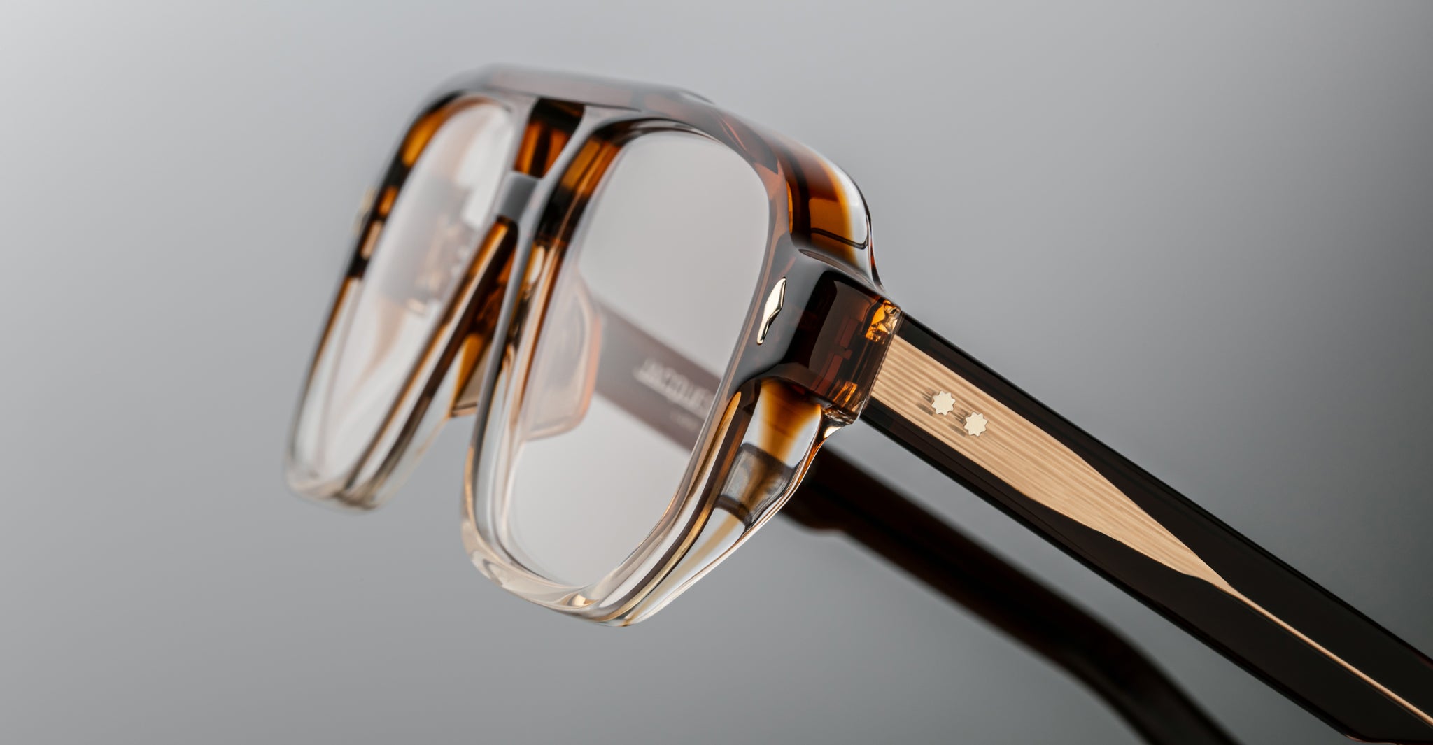 Close-up of Jacques Marie Mage Evans eyeglasses in brown tortoiseshell, featuring clear lenses, an oversized acetate frame with textured detail, and a small metallic accent on the temple.