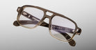 A pair of Jacques Marie Mage Evans eyeglasses featuring an oversized rectangular translucent brown acetate frame with clear lenses, shown on a light gray background.