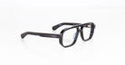 The Jacques Marie Mage Evans are black rectangular eyeglasses with a thick, oversized handcrafted acetate frame by Jacques Marie Mage, elegantly displayed on a white surface.