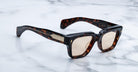 Jacques Marie Mage Fellini tortoiseshell square sunglasses with thick frames and light brown lenses, viewed from above.