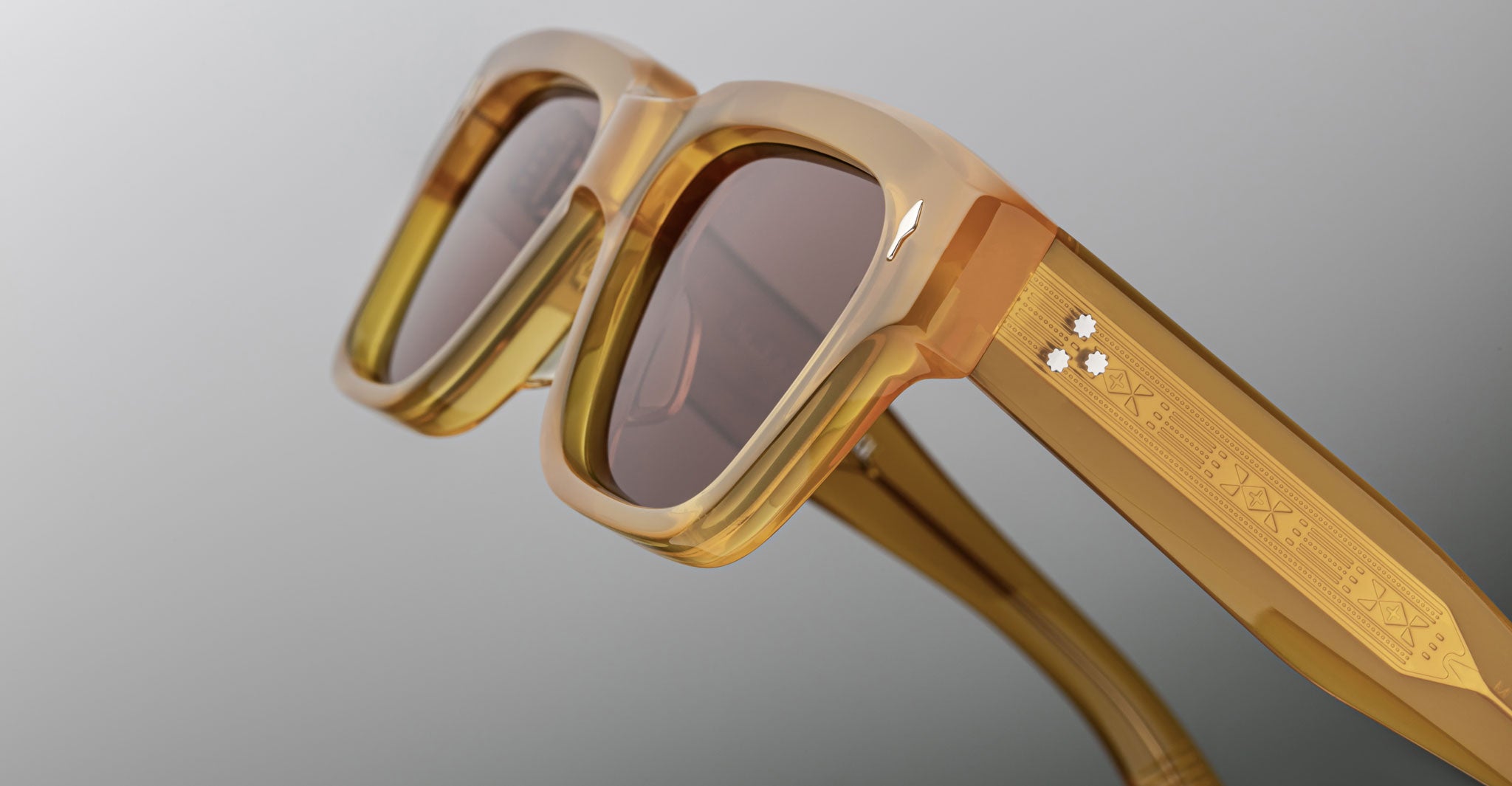Jacques Marie Mage Fellini sunglasses with gold frames, brown lenses, engraved arms, and three gemstones. Front angle view.