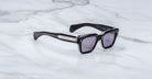 Jacques Marie Mage Fellini black rectangular sunglasses with silver-accented arms, shown from above.
