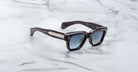 Jacques Marie Mage Fellini black square-framed polarized sunglasses with dark lenses, top-down angle.