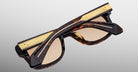 Jacques Marie Mage Fly sunglasses, folded, with gold-accented temples, side view.