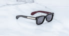 Jacques Marie Mage Fly black rectangular sunglasses with metallic arms, shown from above.