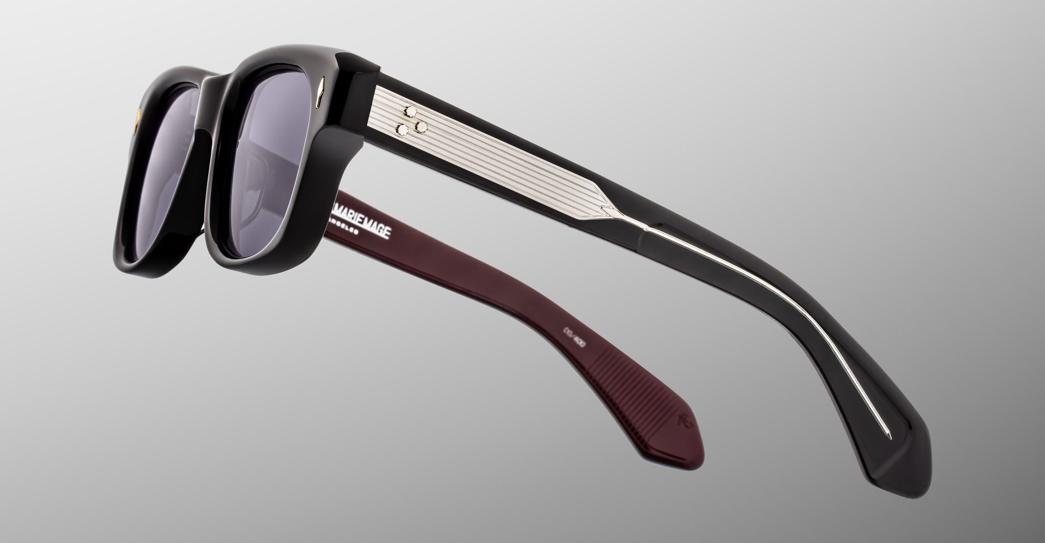 Jacques Marie Mage Fly sunglasses with thick black frames, metallic arms, and maroon temples, front view.