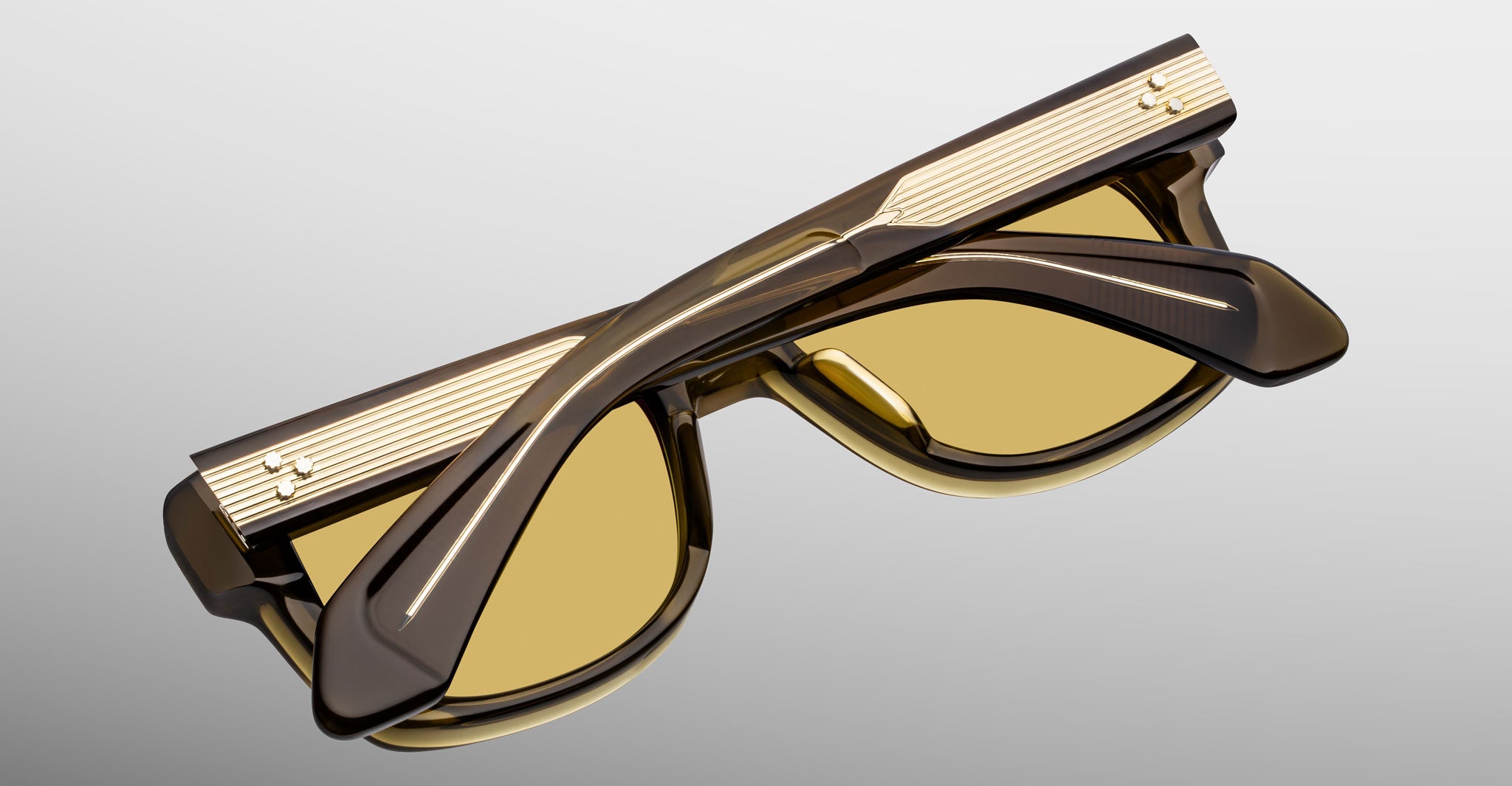 Jacques Marie Mage Fly sunglasses, brown frames with gold accents, viewed from above.
