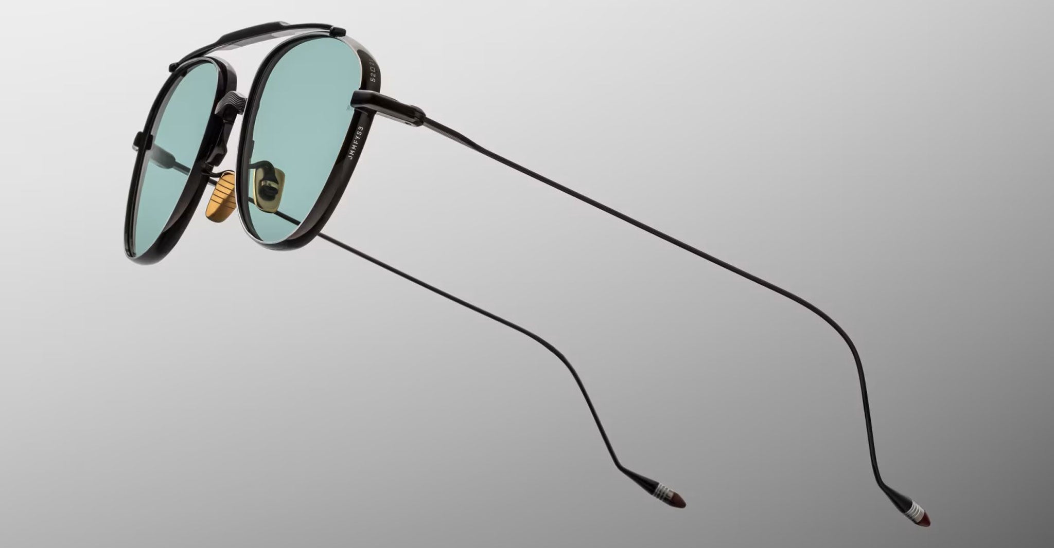 Jacques Marie Mage Flynn sunglasses, black aviator style with green lenses and slim arms, shown from a side angle.