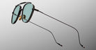 Jacques Marie Mage Flynn sunglasses, black aviator style with green lenses and slim arms, shown from a side angle.