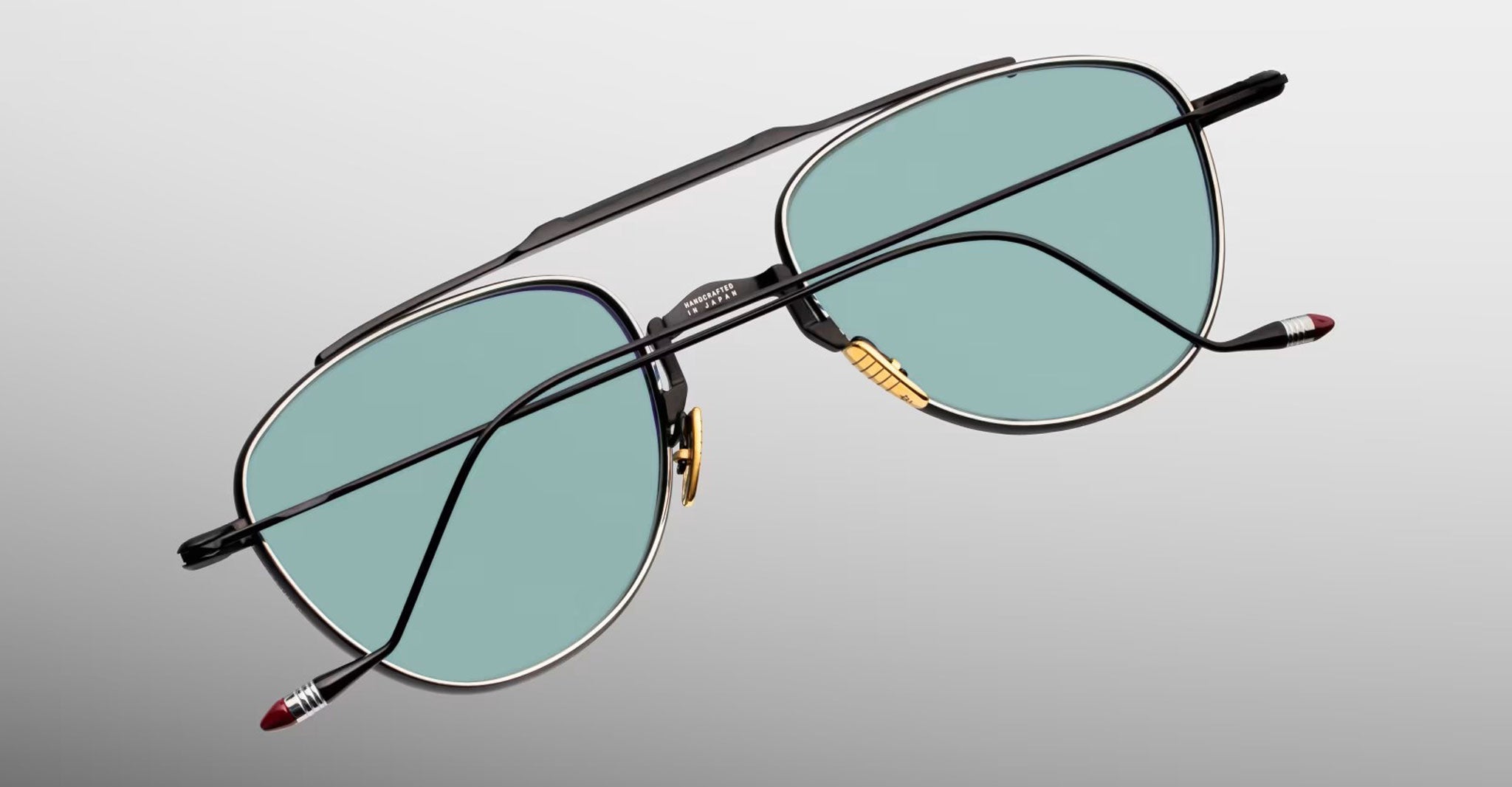 Jacques Marie Mage Flynn aviator eyeglasses, black frames, green-tinted lenses, front view.