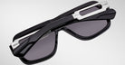 Jacques Marie Mage Fugue sunglasses, black frame with dark lenses and silver accents, shown folded from side angle.