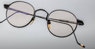 A pair of Jacques Marie Mage Full Metal Jacket round eyeglasses with metal frames, clear lenses, gold nose pad accents, black temple arms, and FULL METAL JACKET inscribed on the right arm.