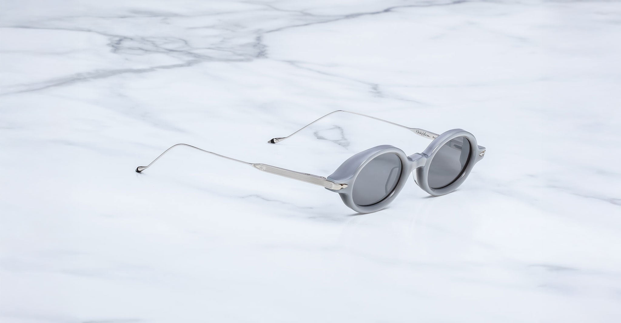 Jacques Marie Mage Balthazar sunglasses with slim metal arms, viewed from above, on display.