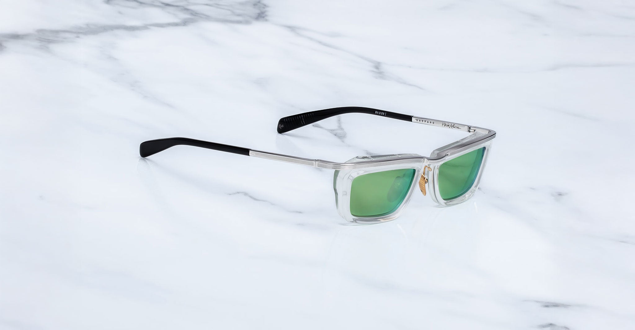 Jacques Marie Mage Gaspard square sunglasses, clear frames, green lenses, black arms, shown from the front.