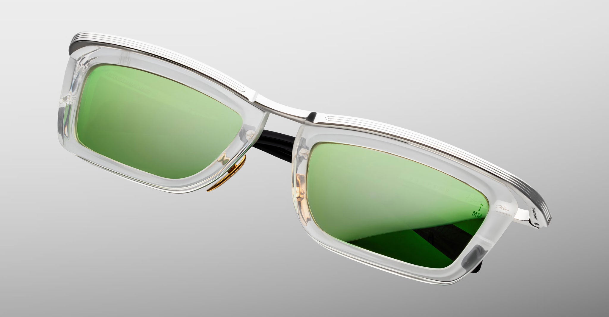 Jacques Marie Mage Gaspard sunglasses, clear frames, green polarized lenses, metallic accents, shown from the front angle.