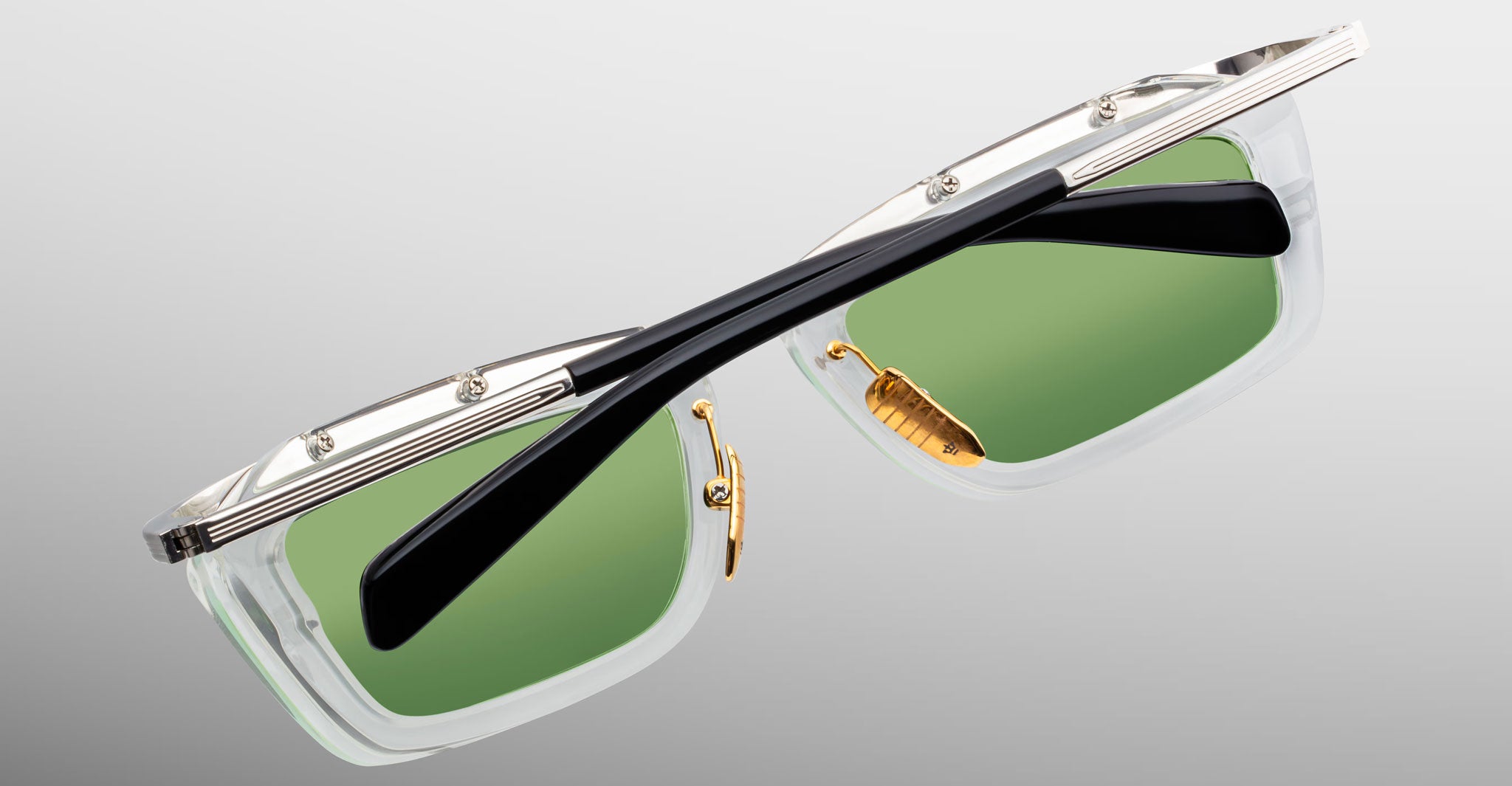 Jacques Marie Mage Gaspard sunglasses, front view, featuring clear frames, green lenses, gold accents, and black arms.