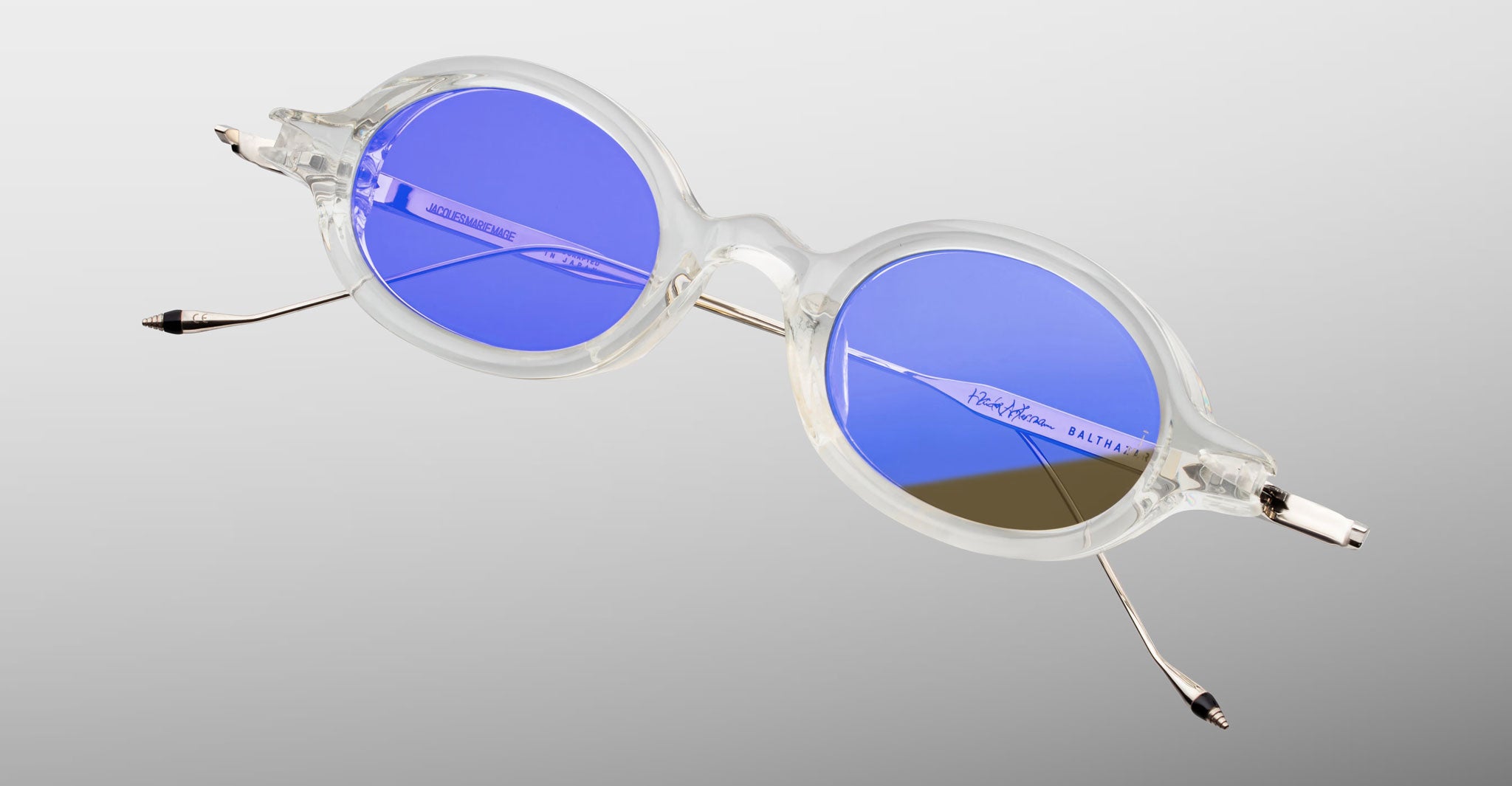 Jacques Marie Mage Balthazar eyeglasses, round blue-tinted UV-protected lenses, thin metal arms, shown from the front angle.