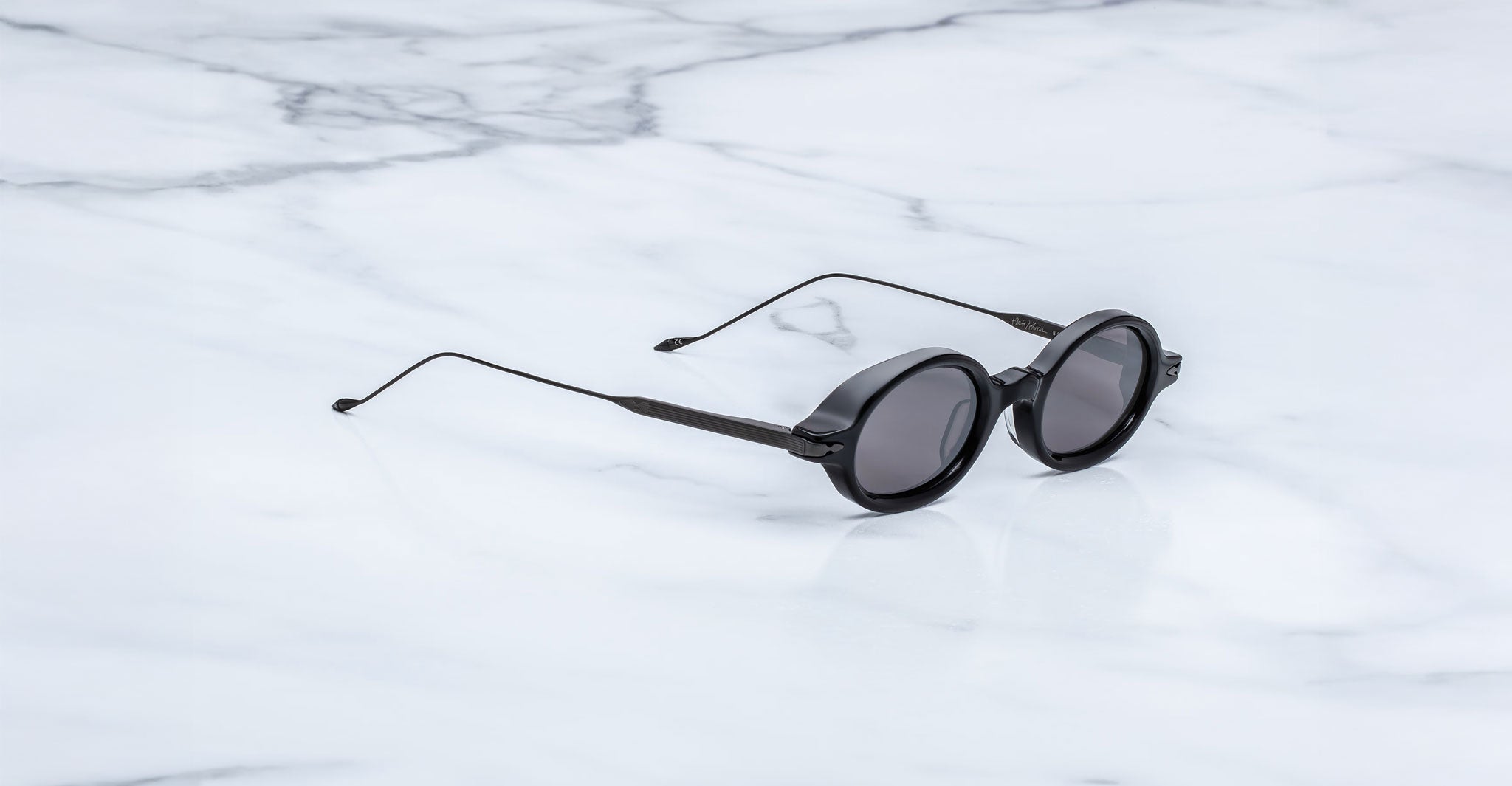 Jacques Marie Mage Balthazar black round sunglasses with thin arms, shown from side angle.