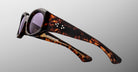 Jacques Marie Mage Gia in Beau tortoiseshell sunglasses with thick frames and purple lenses, profile view.