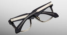 Jacques Marie Mage Hyannis in Black Fade eyeglasses, black and gold thick frames, folded, product viewed from back angle.