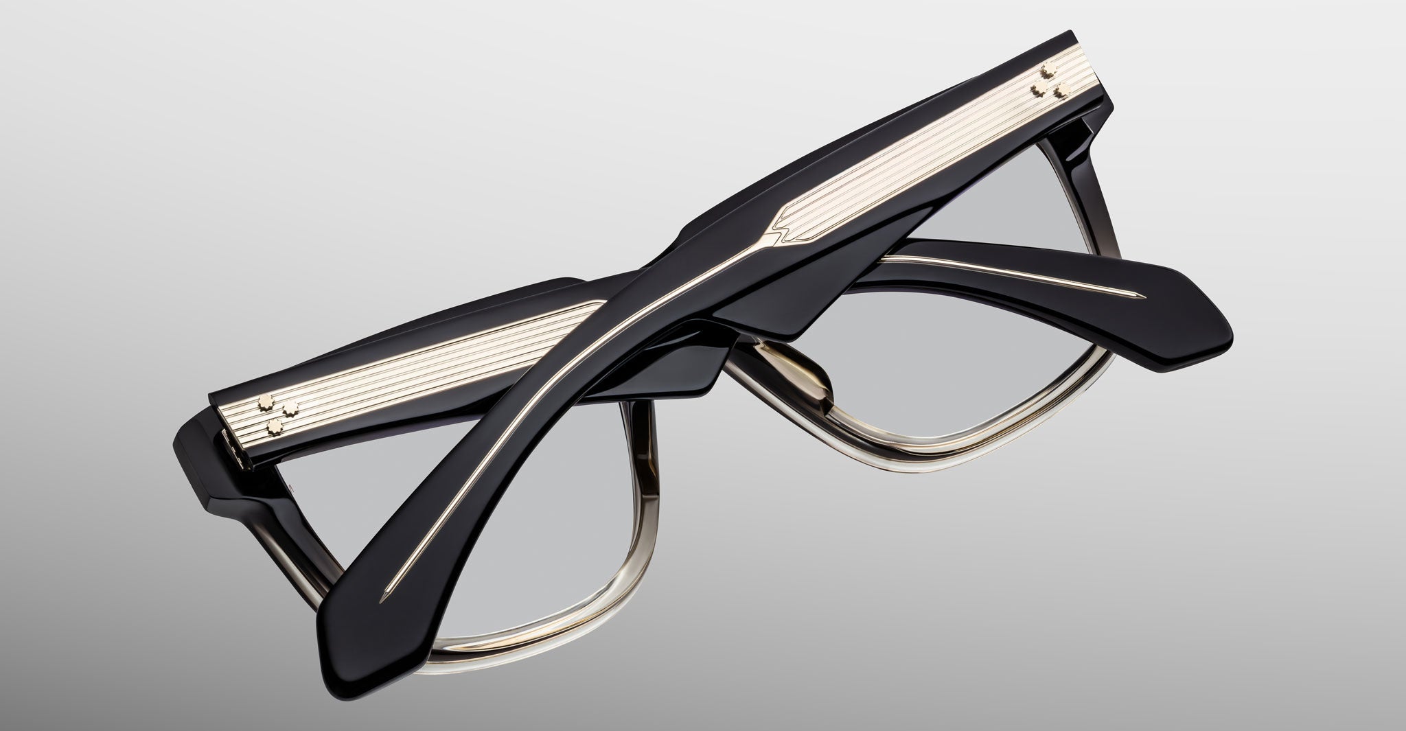 Jacques Marie Mage Hyannis in Black Fade eyeglasses, black and gold thick frames, folded, product viewed from back angle.