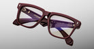 Close-up of Jacques Marie Mage Hyannis in Bordeaux burgundy rectangular eyeglasses with clear lenses; lightweight frames, brand name on inner arms.