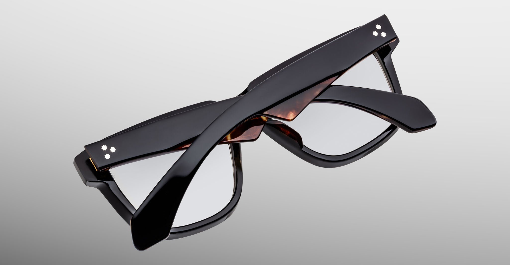 Jacques Marie Mage Hyannis in Noir q5 eyeglasses, black frames with tortoiseshell accents, folded, top-down back view.