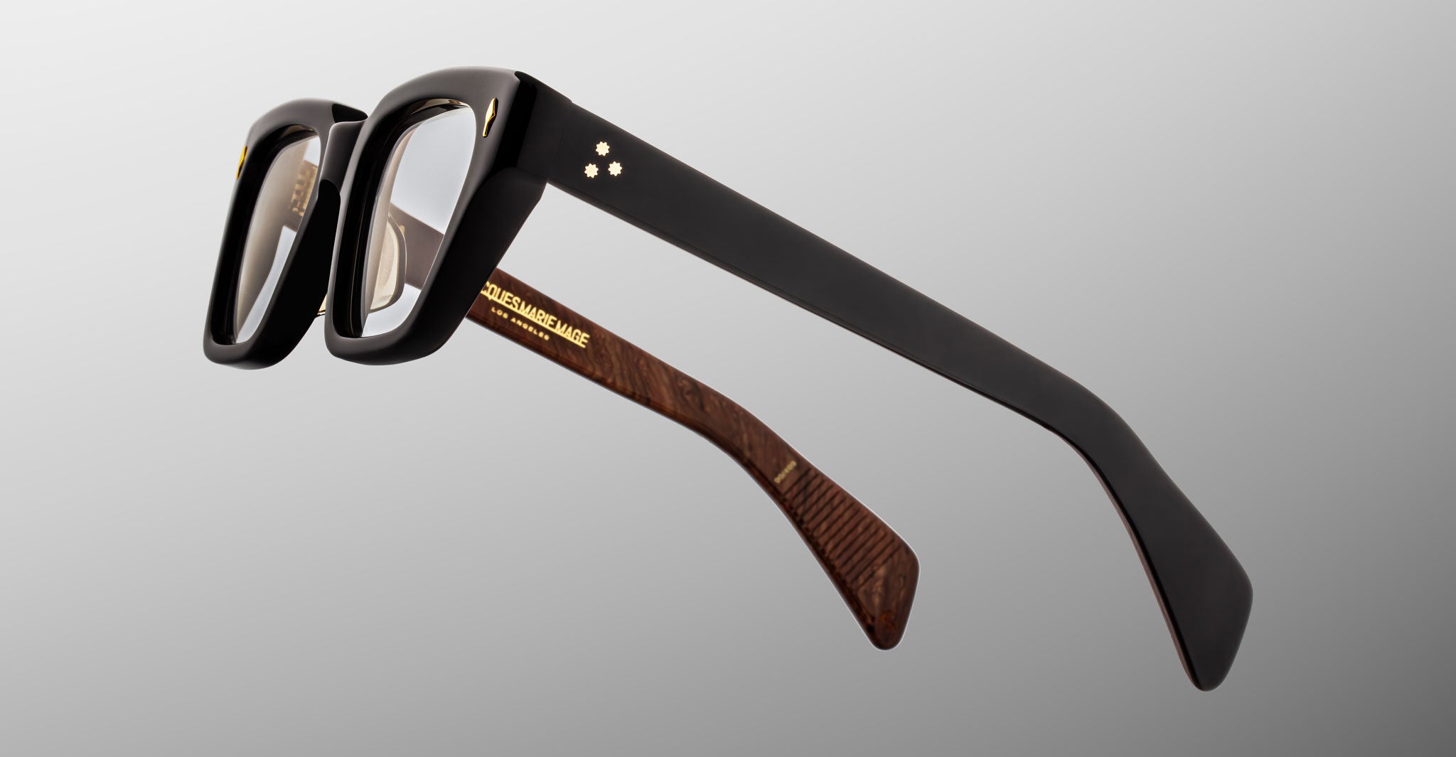 Jacques Marie Mage Ichikawa eyeglasses, black rectangular frames with gold accents and wood-textured temples, front angle view.