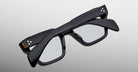 Jacques Marie Mage Ichikawa black rectangular eyeglasses with arms folded, side view.