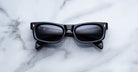 Jacques Marie Mage Initials in Lacquer rectangular dark blue sunglasses with dark lenses, front view.