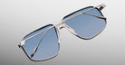 Jacques Marie Mage Jagger oversized aviator sunglasses with silver frames and blue-tinted beta titanium lenses by Jacques Marie Mage, shown against a gradient gray background.