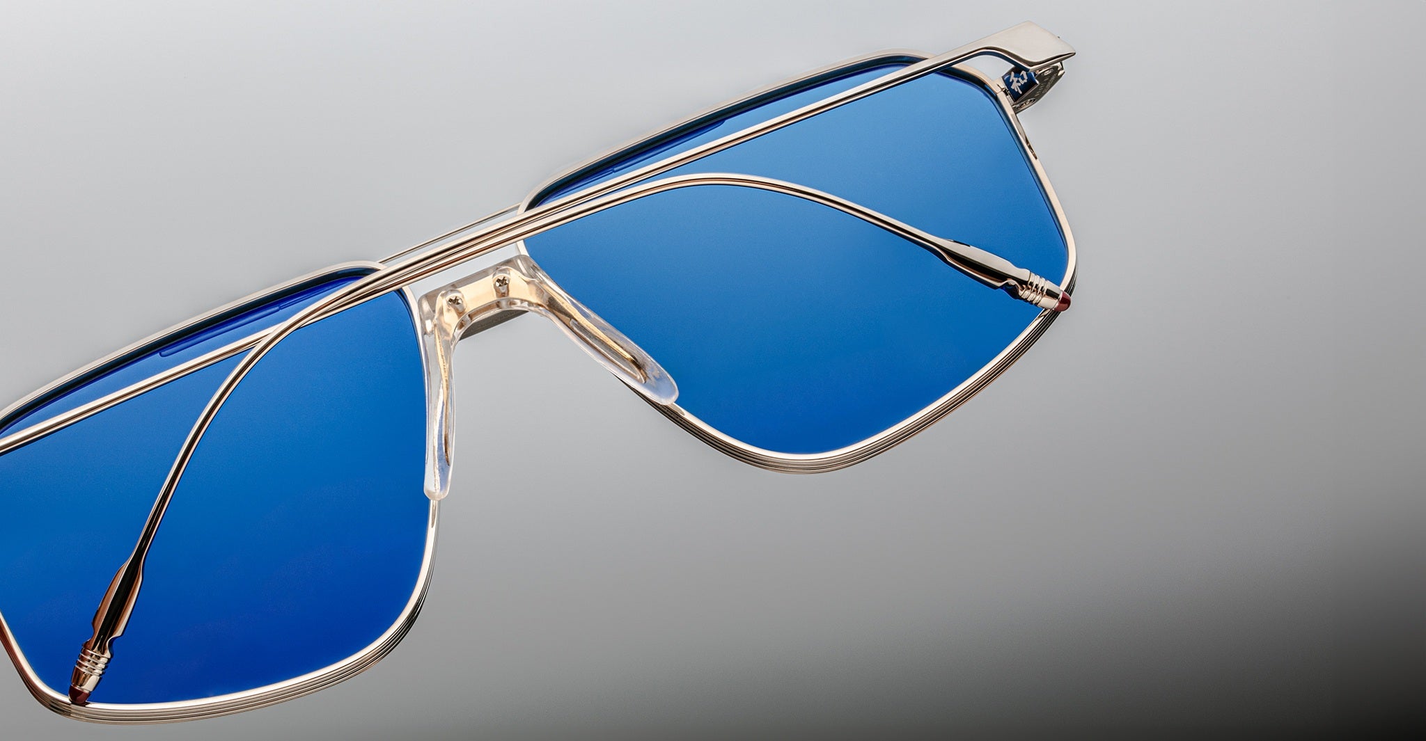 Close-up of Jacques Marie Mage Jagger sunglasses featuring oversized aviator design, blue-tinted lenses, and a sleek beta titanium metallic frame by Jacques Marie Mage, displayed on a neutral background.