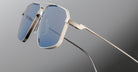Close-up of Jacques Marie Mage Jagger oversized aviator sunglasses by Jacques Marie Mage, featuring blue-tinted lenses and sleek beta titanium frames against a neutral background.