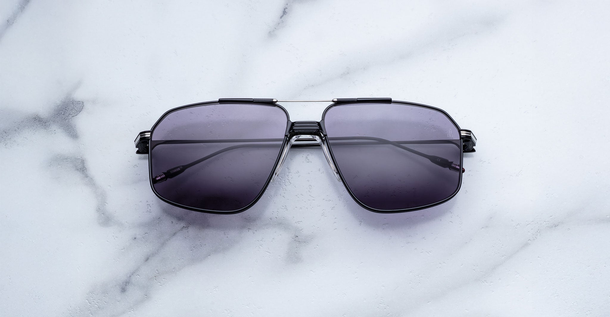 Jacques Marie Mage Jagger oversized aviator sunglasses with dark tinted lenses by Jacques Marie Mage, displayed on a white marble surface.