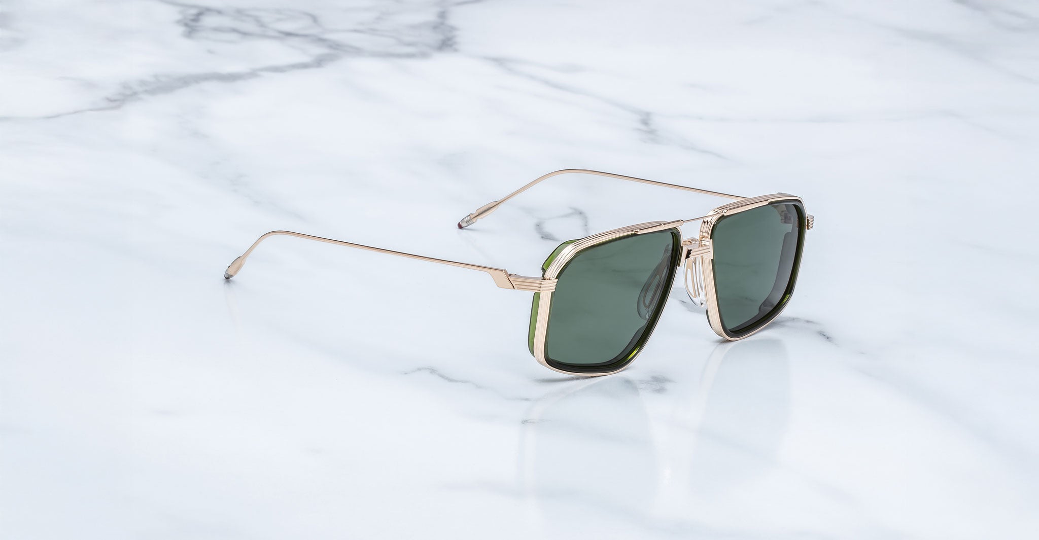Jacques Marie Mage Jagger sunglasses, gold frame and green lenses, viewed from above.