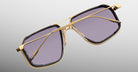 Jacques Marie Mage Jagger sunglasses with gold frames and rectangular purple lenses, shown from the front.
