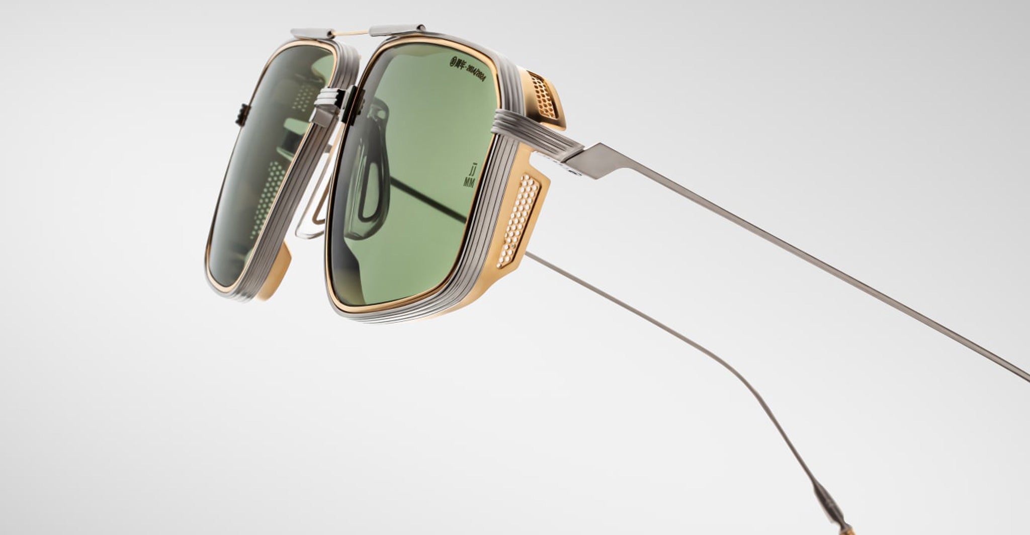 The Jacques Marie Mage Jagger sunglasses feature oversized aviator green lenses, metallic gold and silver beta titanium frames, and sleek long temples by Jacques Marie Mage, photographed against a plain background.