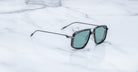Jacques Marie Mage Jagger sunglasses with black rims and green lenses, shown from above.