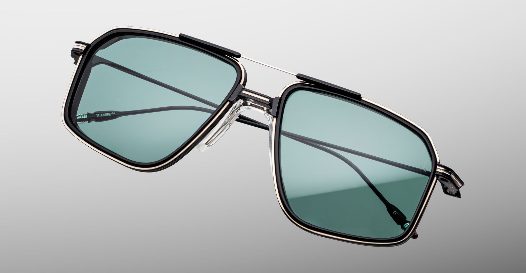 Jacques Marie Mage Jagger sunglasses, rectangular shape, teal lenses, black and silver metal frame, front view.