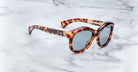 Jacques Marie Mage Jennie round tortoiseshell sunglasses with blue lenses, shown from above.