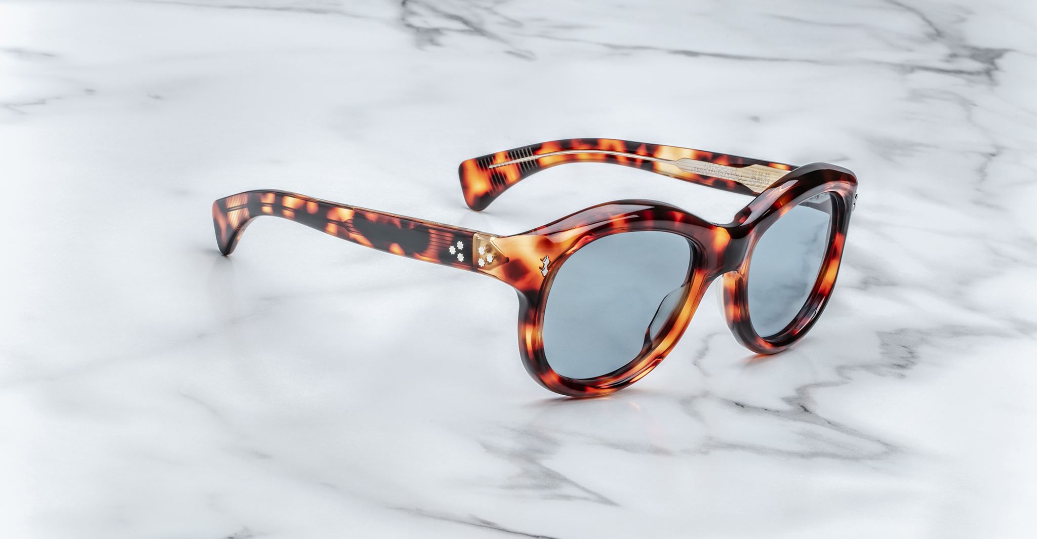 Jacques Marie Mage Jennie round tortoiseshell sunglasses with blue lenses, shown from above.