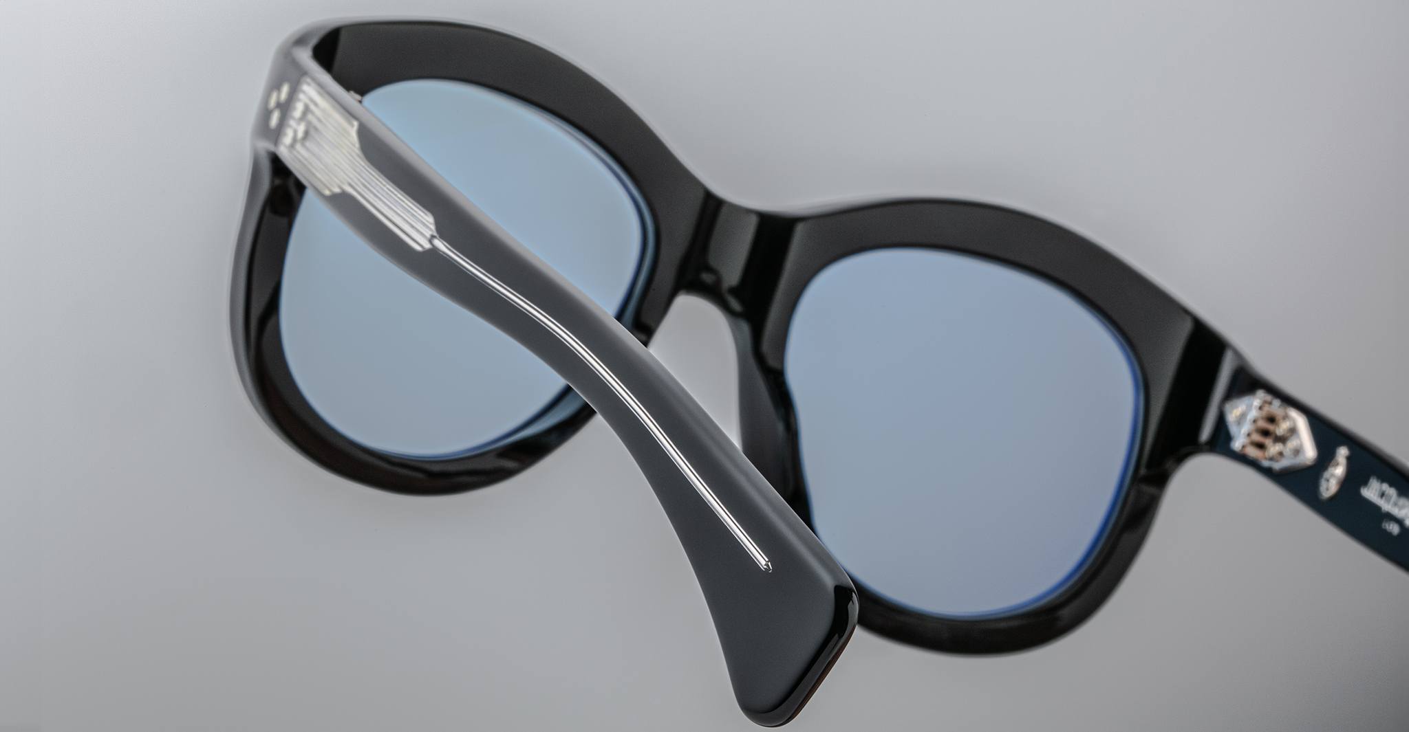 Close-up of the back of Jacques Marie Mage Jennie sunglasses showing blue-tinted lenses and a silver accent on the frame.