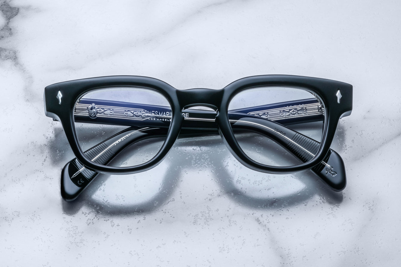 Jacques Marie Mage Julien in Titan black rectangular optical frame in acetate with cool-toned undertones, featuring a keyhole bridge, signature arrowhead front pins, and exposed metal core detailing within the temples, shown with clear lenses.
