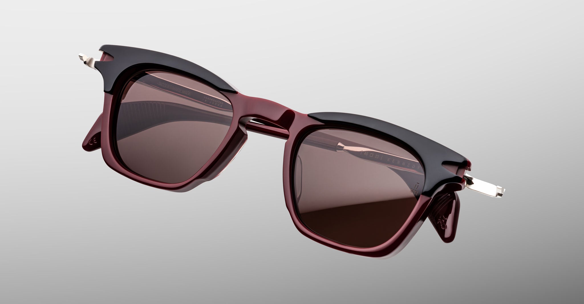 Jacques Marie Mage Kennedy rectangular maroon sunglasses with black accents and dark UV lenses, shown from the front angle.