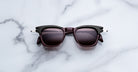 Jacques Marie Mage Kennedy sunglasses in black and dark brown with dark lenses, viewed from above.