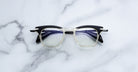 Jacques Marie Mage Kennedy eyeglasses in black and clear, front view, rectangular frame, acetate material.