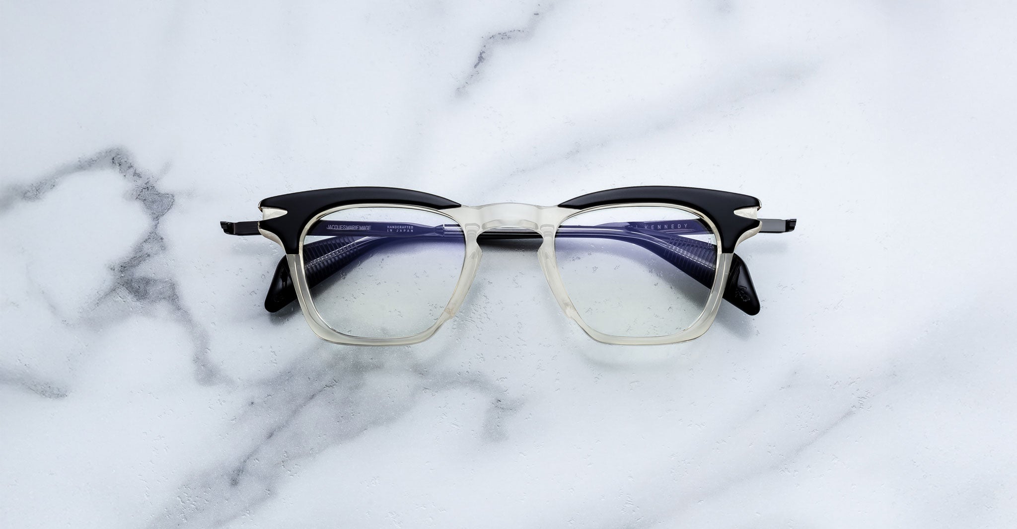 Jacques Marie Mage Kennedy eyeglasses in black and clear, front view, rectangular frame, acetate material.