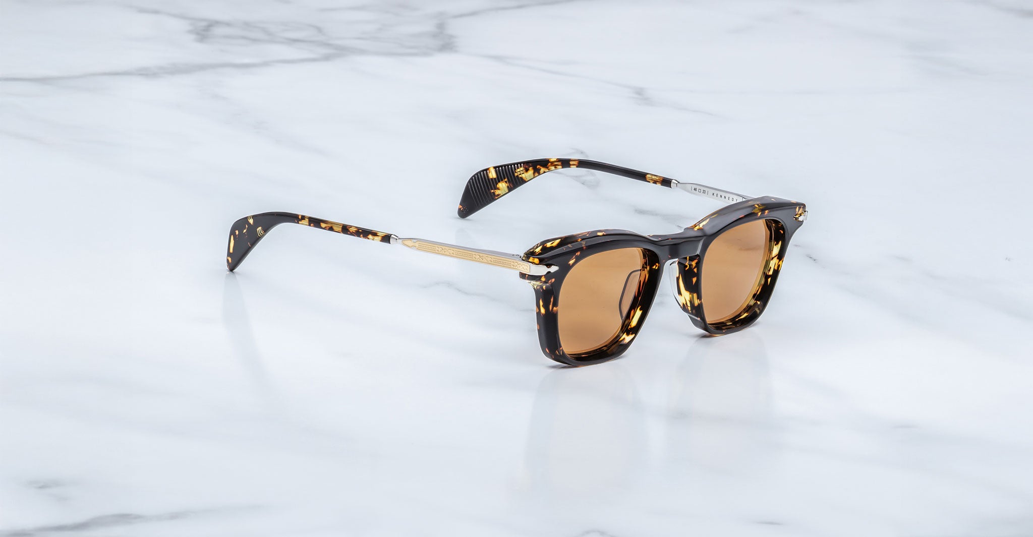 Jacques Marie Mage Kennedy sunglasses with brown lenses and gold accents, viewed from above.