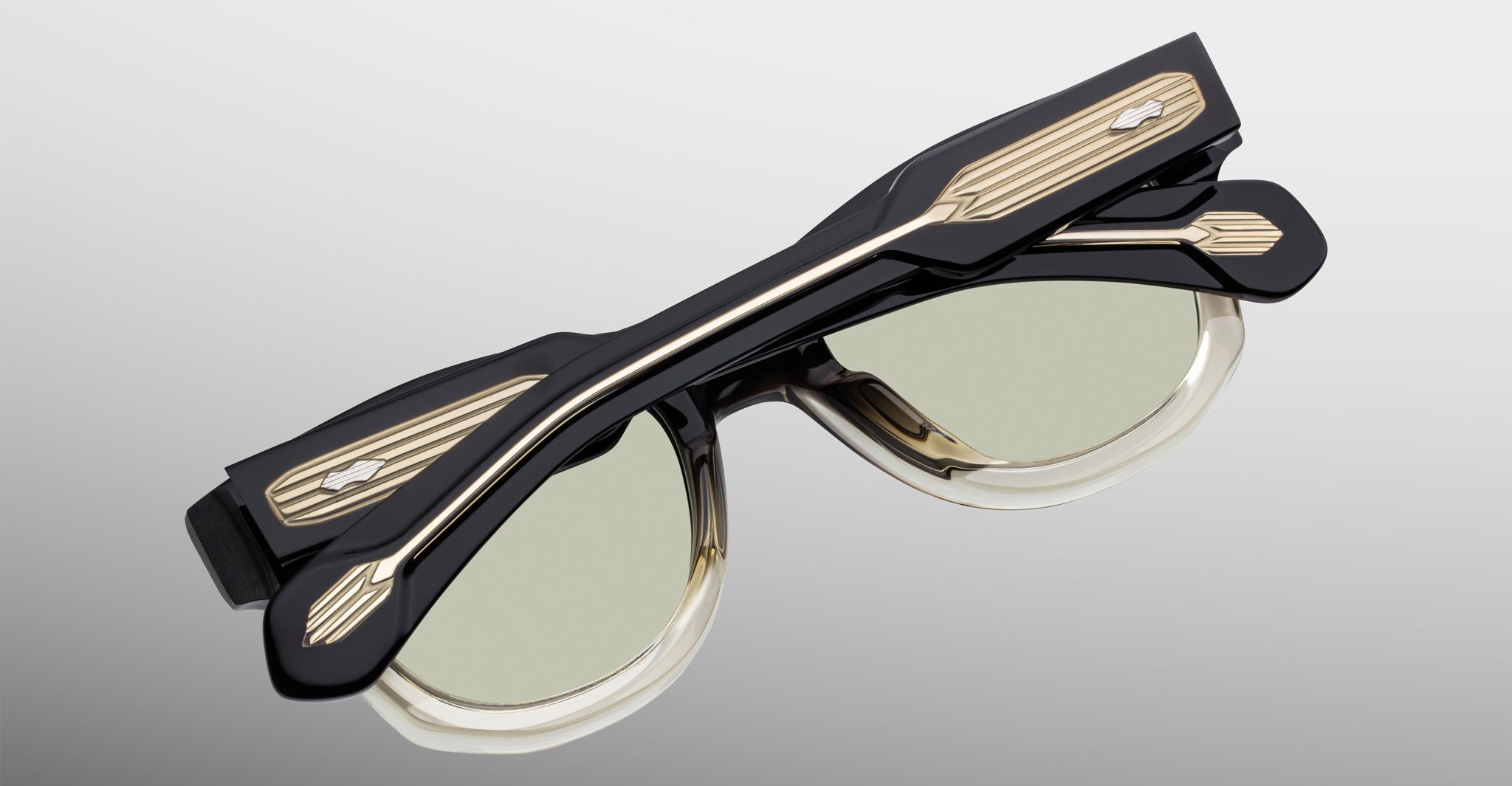 Jacques Marie Mage Kinshasa eyeglasses, black and gold frame with clear lenses, shown folded, front angle.